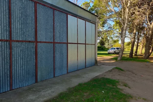 Estructura metálica y acceso vehicular en finca rural en Buenos Aires.
