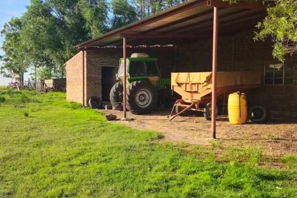 Tractor y equipo de trabajo guardados en galpón de finca rural en Buenos Aires.